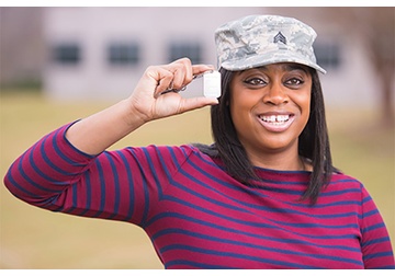 Image of female veteram holding military tag