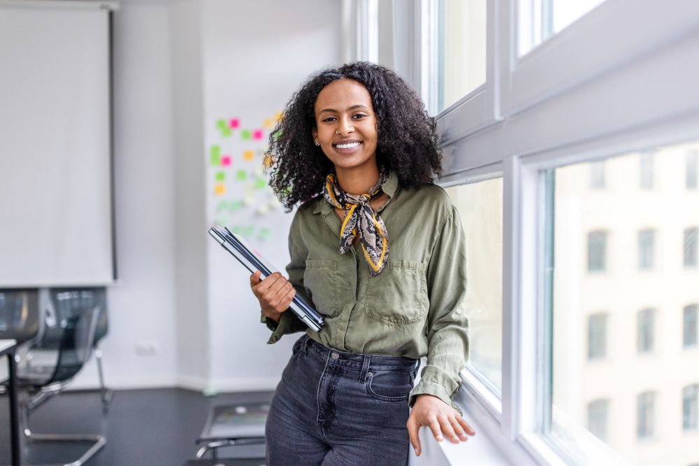 woman leaning against window with clipboard