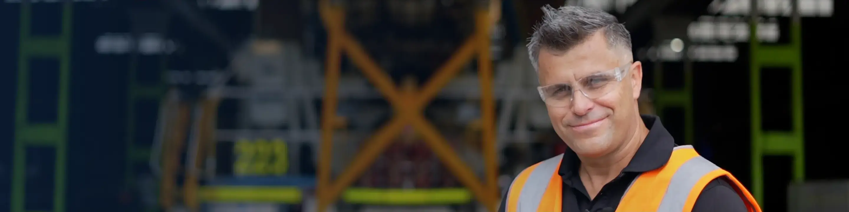 Smiling man in a orange and yellow safety vest