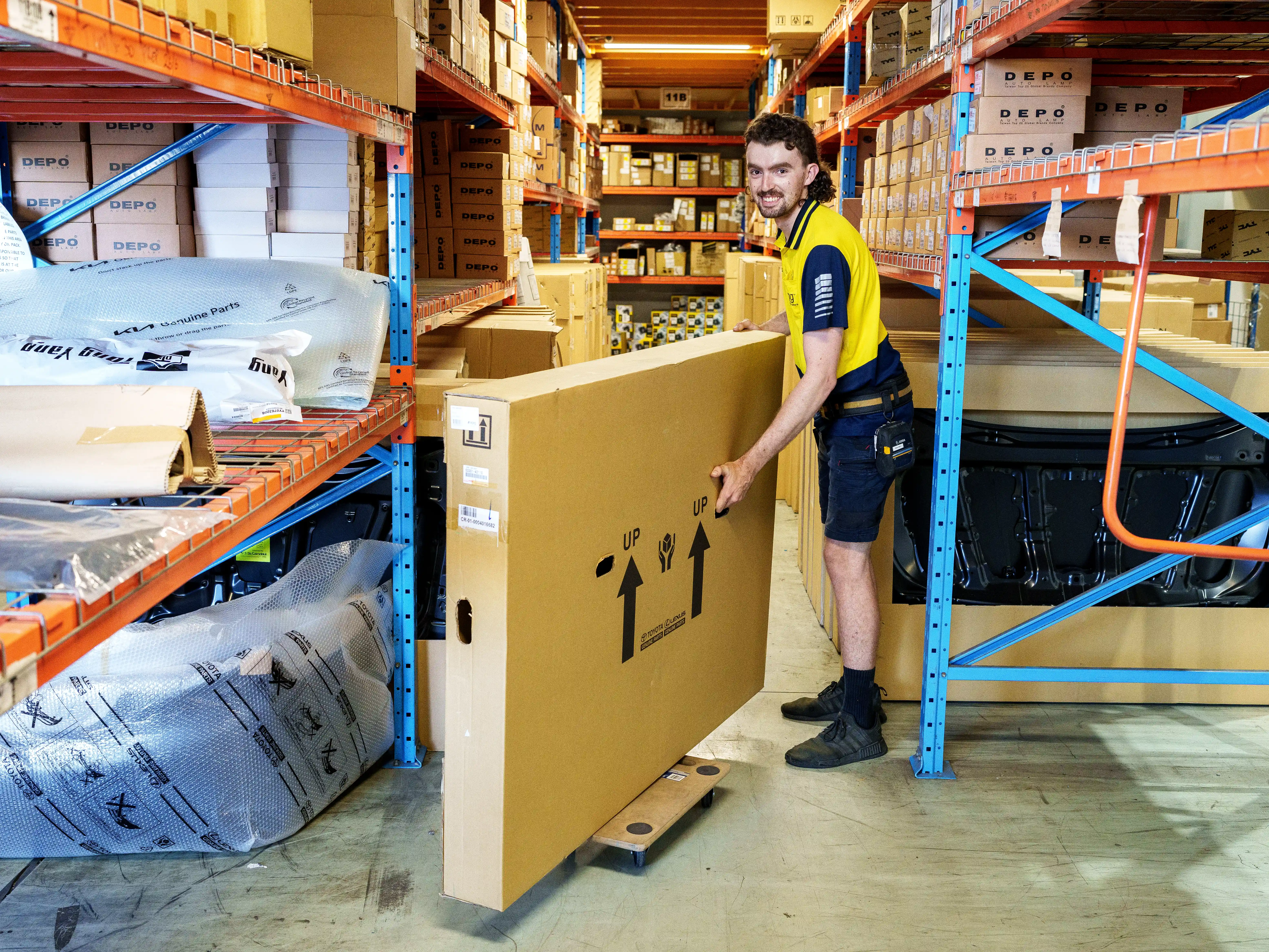 A warehouse setting with APG employees working around equipment and boxes, emphasizing workplace safety and organization.