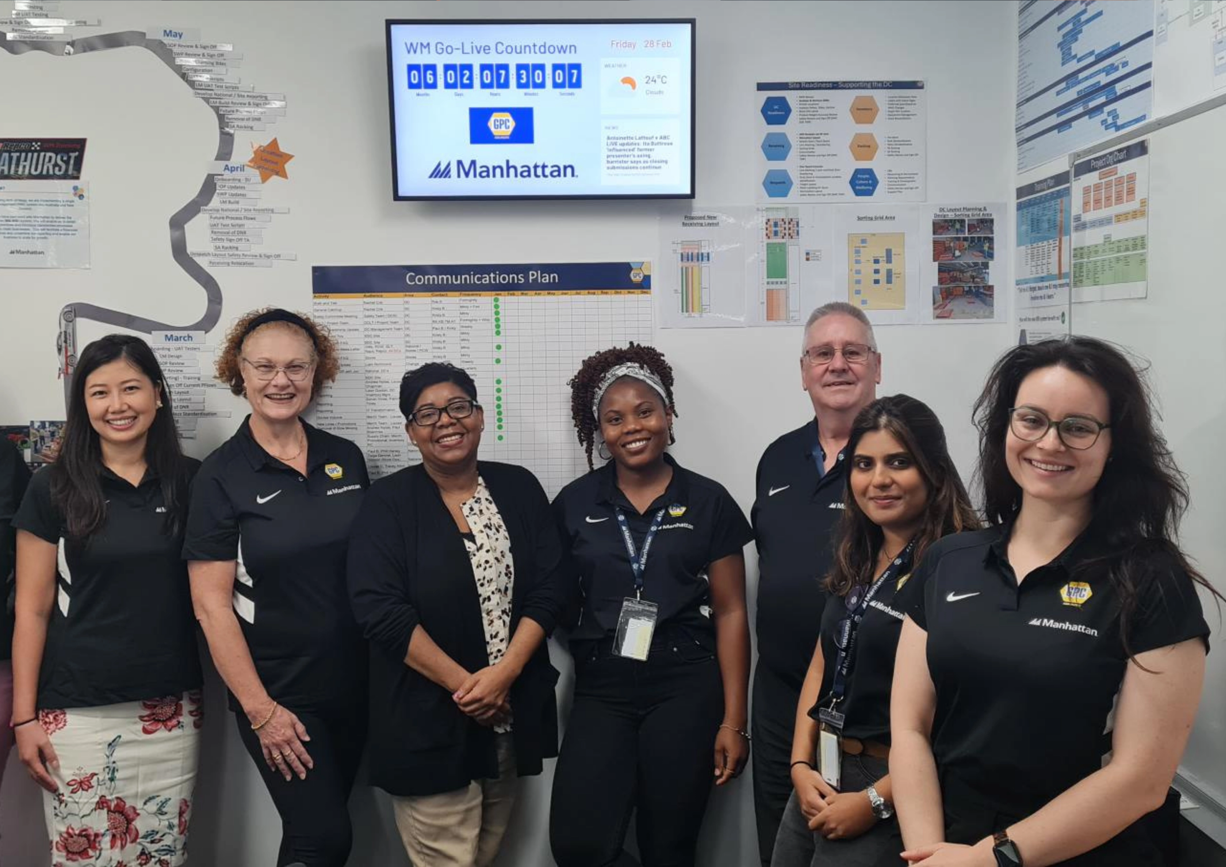 Group of employees standing in a communities room, smiling.