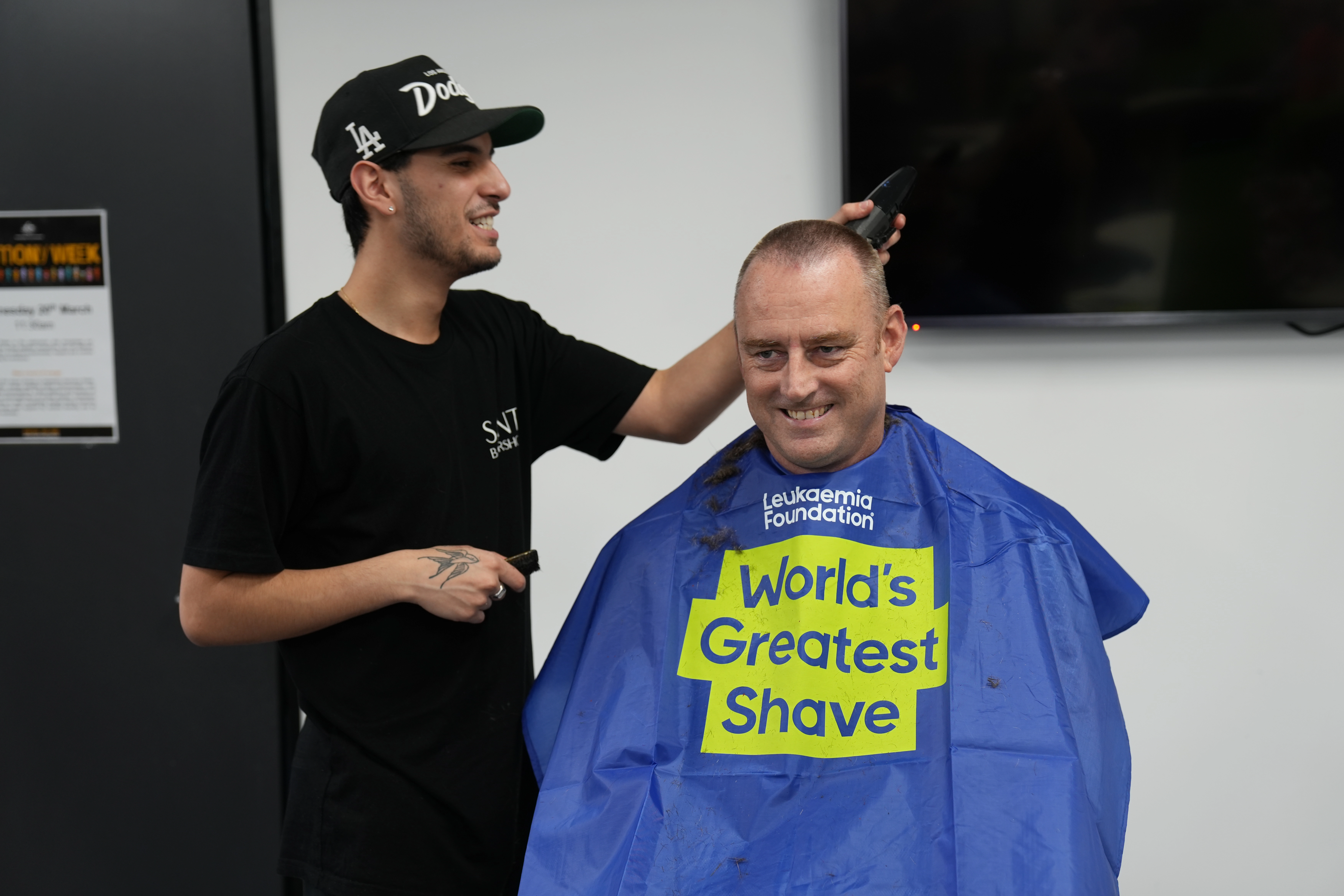 Man getting head shaved during communities event.