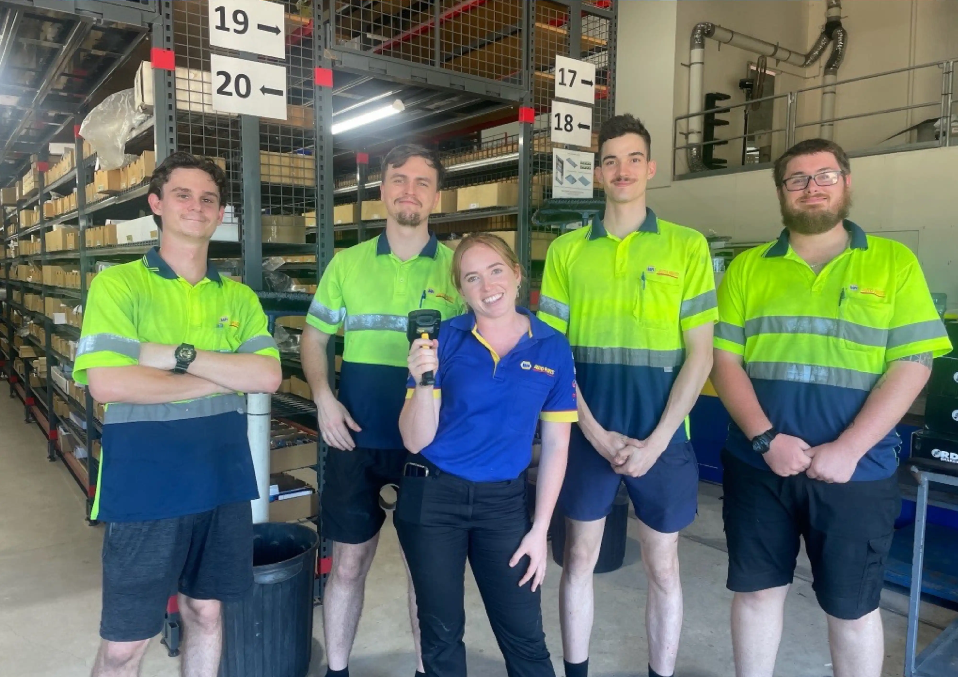 NAPA staff in green and blue uniforms inside a store or warehouse.
