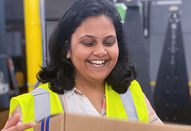 Woman smiling while holding a box