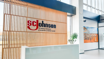 Front desk with SC Johnson logo on wooden beams behind desk