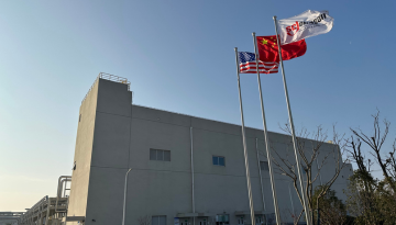 Exterior of Jinshan manufacturing plant with blue sky and flags flying