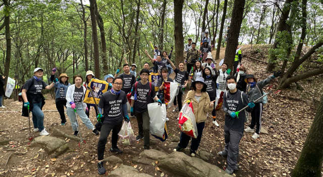 Group photo of SCJ China team members cleaning up waste from a forest