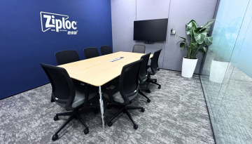 Meeting room with table and chairs, Ziploc China logo on the wall