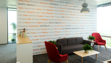 Seating area with text mural listing SCJ country operations on wall
