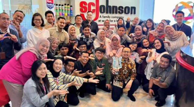 Indonesia team in lobby of office posing with an environmental award