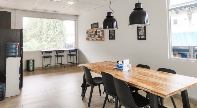 Break room area with tables, chairs, refrigerator