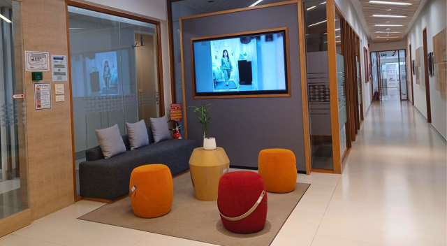 Seating area near hallway with monitor on wall