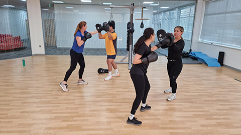 Four team members doing a boxing workout in a gym