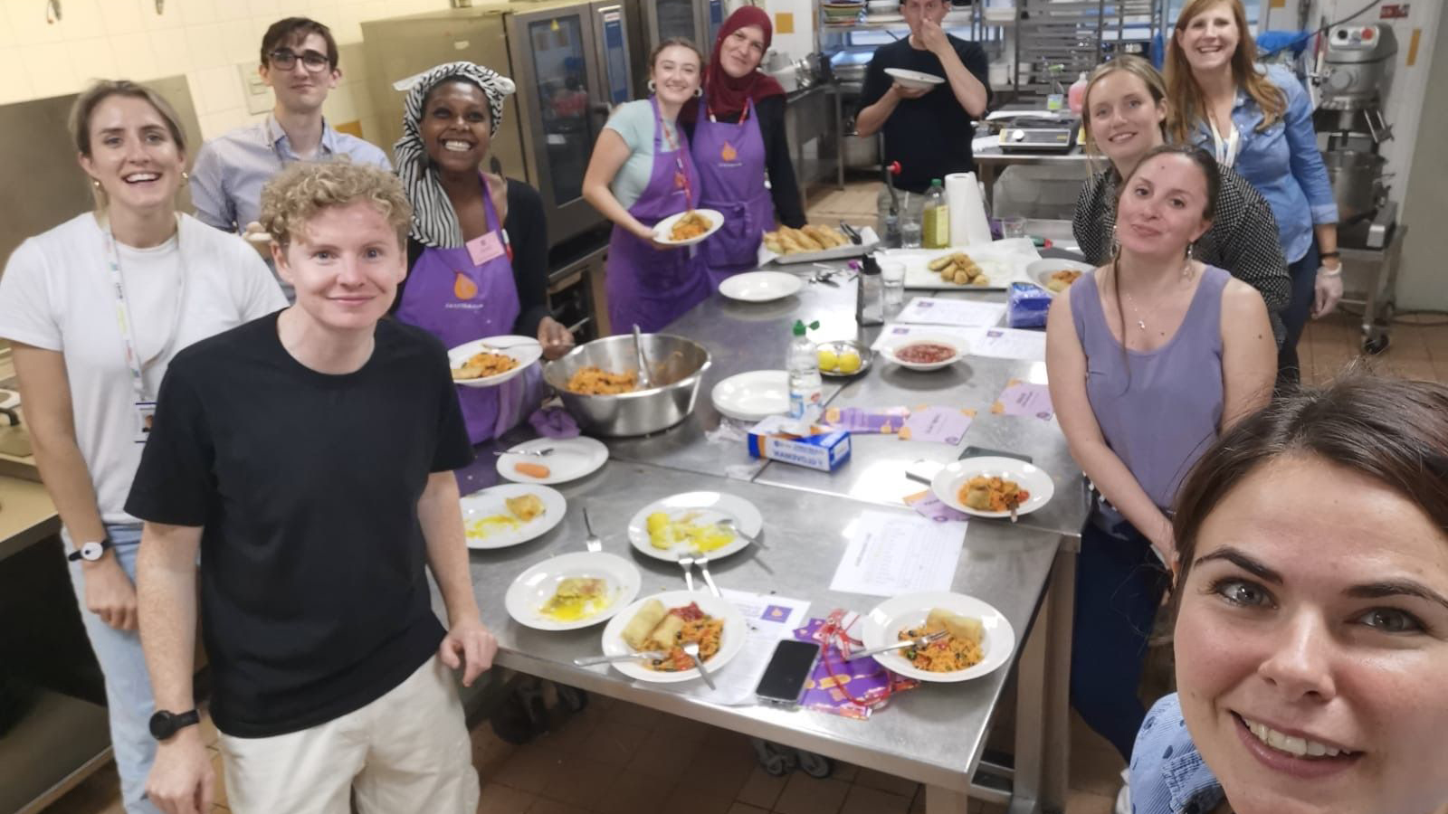 LSB team members around kitchen counter learning to cook recipes with charity partner