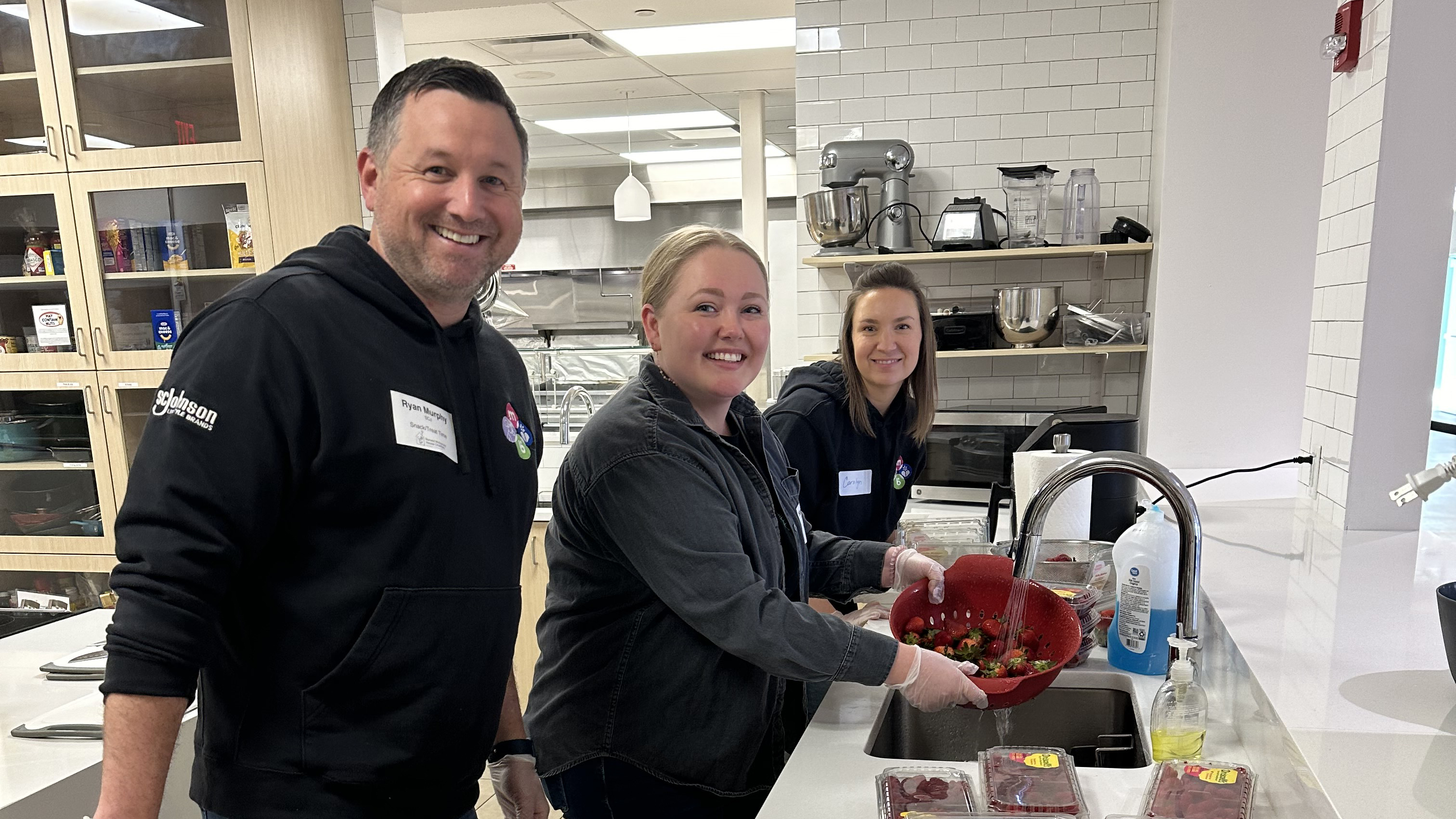 Three LSB team members preparing snack cups for Ronald McDonald House families