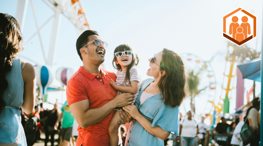 Mother and father posing with happy child at festival event