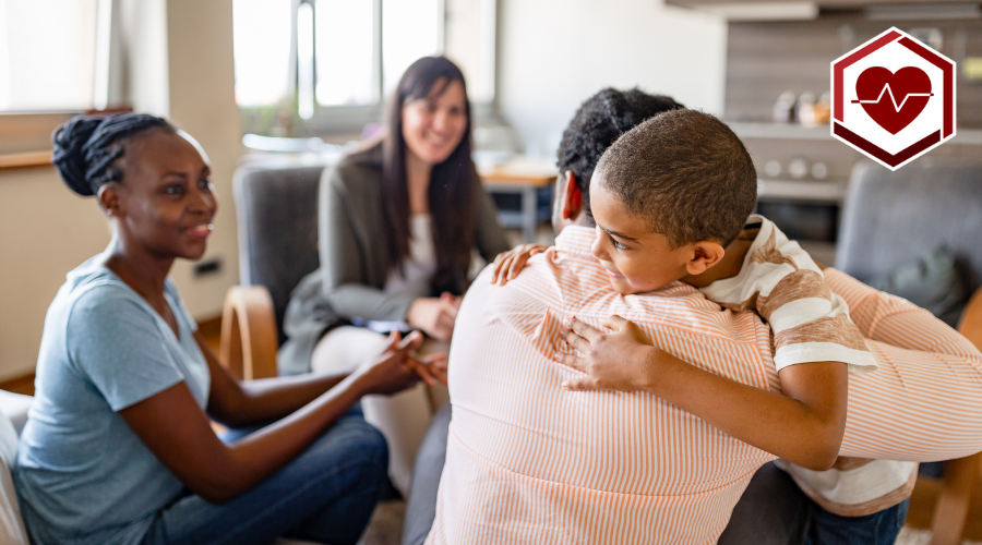 Father holding son at doctor appointment with individuals in background