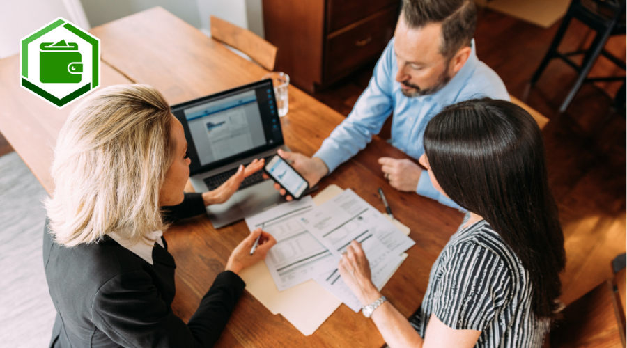 Three people discussing finances around a computer