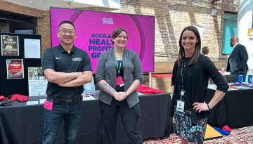 Three SCJ team members standing in front of table display for company wellness initiatives at SCJ Learning Week