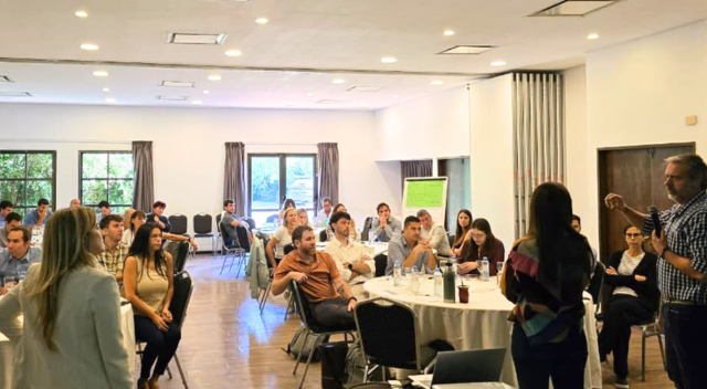 A presenter in front of a group of dozens of SCJ people sitting to watch the presentation