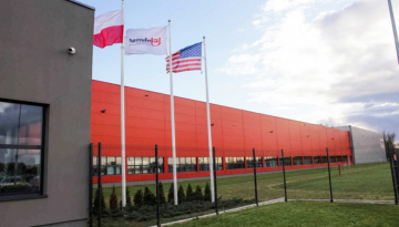 Three flags flying outside the office building. Flag of Poland, flag with SC Johnson logo and flag of the United States.