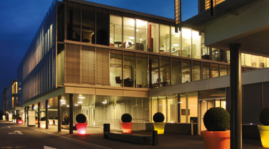 Exterior of SC Johnson Switzerland office - building lit up with night sky in background