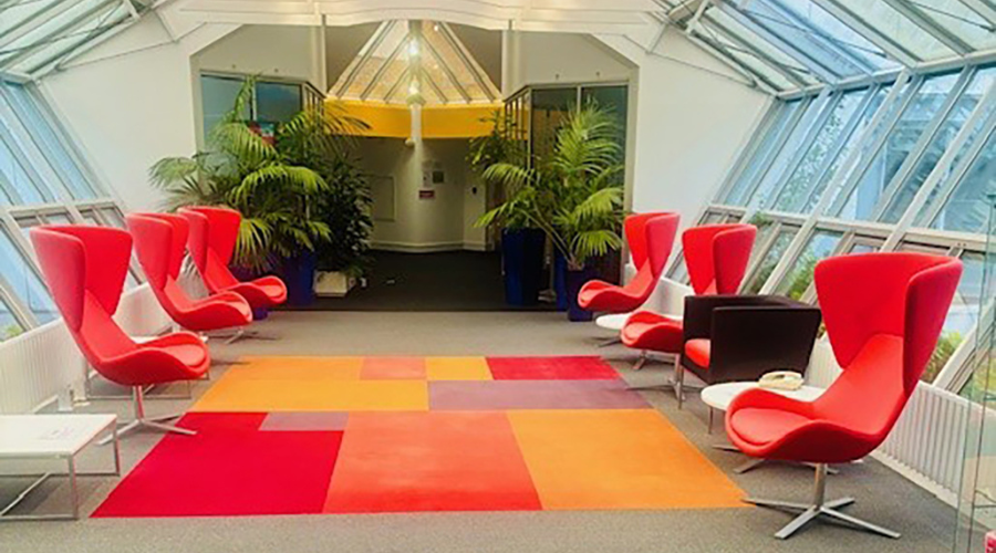 SCJ UK lobby atrium - red chairs with greenery in background