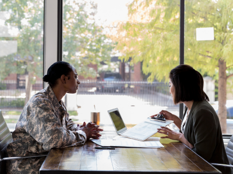 A Veteran and employer discussing qualifications at a table