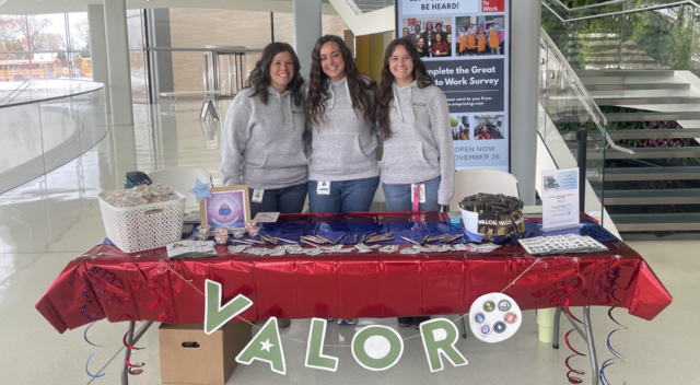 SCJ team members on Veterans Day with a table for others to learn about ERG group VALOR