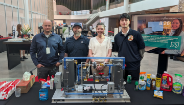 Four SCJ team members standing behind a table display at SCJ Learning Week
