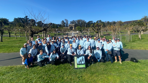 Group photo of LSB team members at a volunteering event - dozens of people in matching shirts volunteering at a park clean up