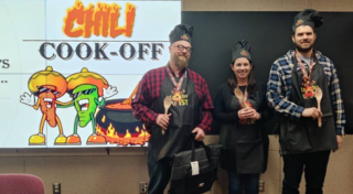 Three team members posing after winning chili cookoff championship