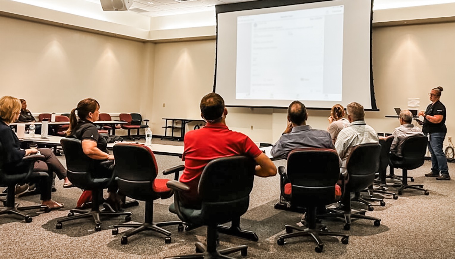 Team listening to presenter at front of room