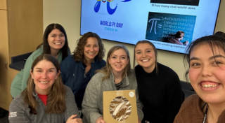 Waxdale HR team posing together with a pie for Pi Day celebration