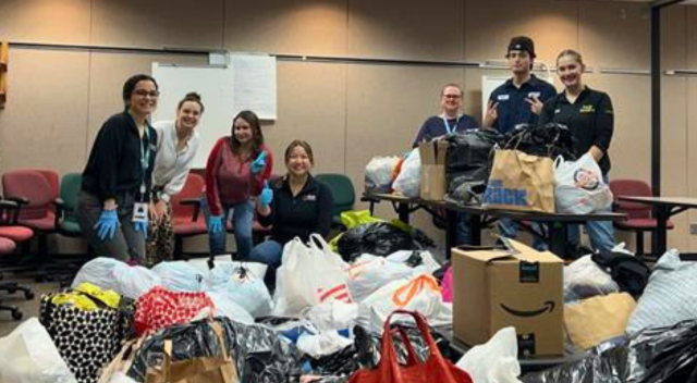 Team members posing with donations collected for local non-profit