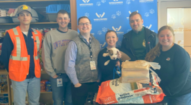 Six team members donating pet supplies to local non-profit