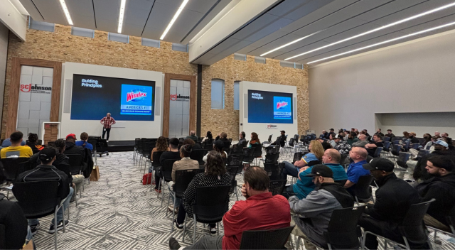 Team listening to presentation at front of meeting room