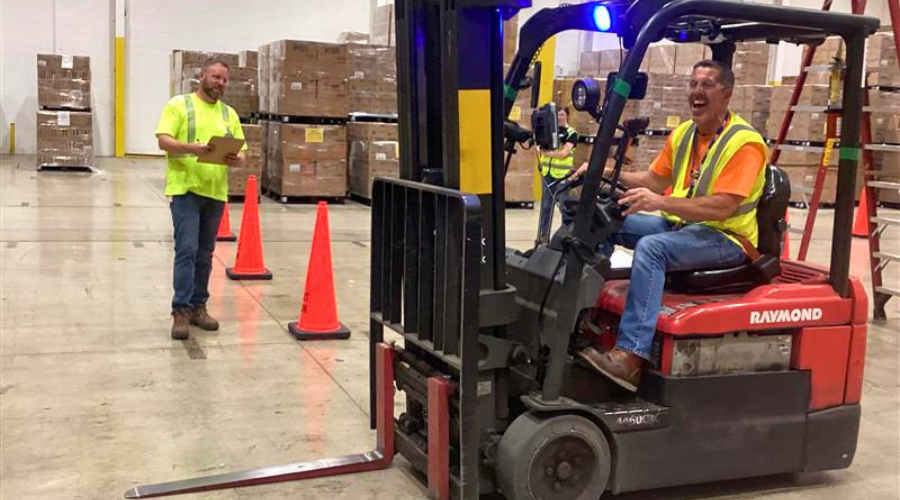 Team member driving fork lift through skills test course