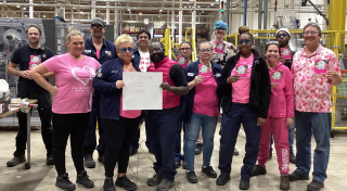 12 Waxdale team members posing for a group photo in pink shirts during Breast Cancer Awareness Month