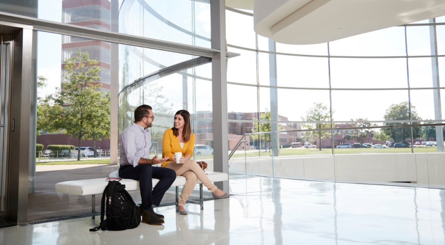 Two team members conversing in lobby of Forteleza Hall