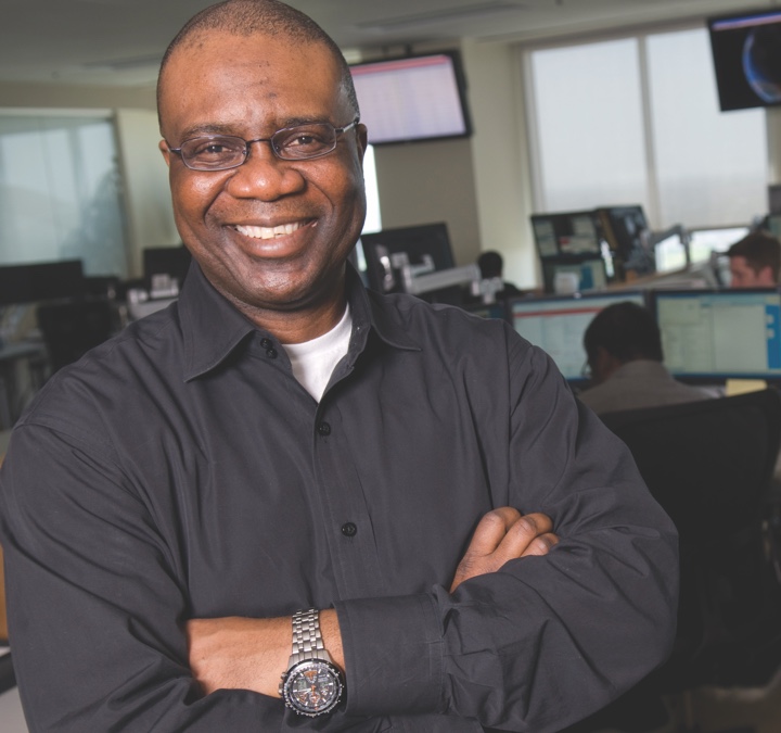 Man with grey shirt and wearing glasses with his arms folded