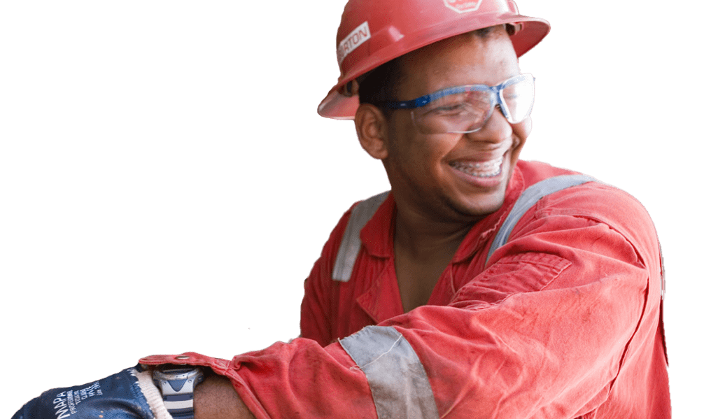 Man with red hard hat and protective glasses smiling