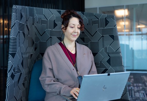 US Employee standing inside Intel campus working on a laptop