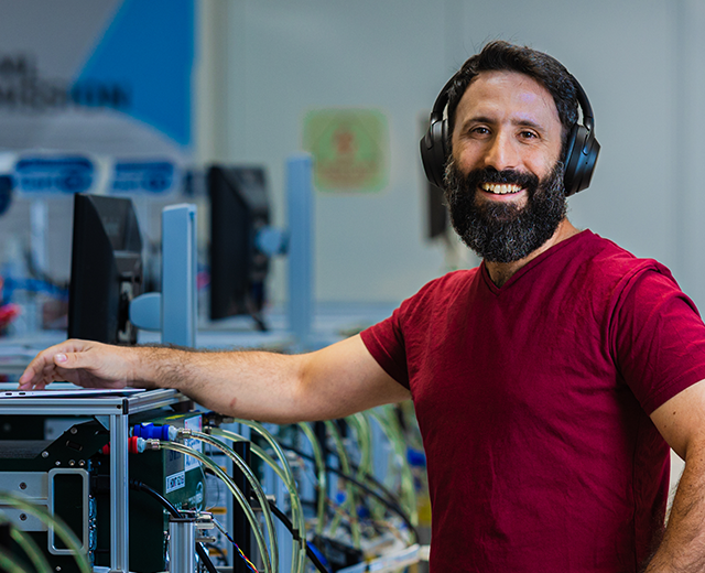 Silicon Photonics engineer in a lab wearing headphones and red shirt