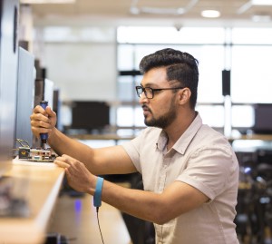 Male Indian engineer in lab working on equipment