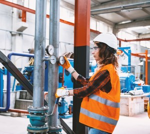 Woman working with ball valves in factory