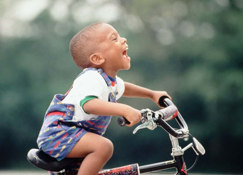 boy laughing on bike