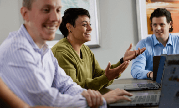 employees laughing and talking at conference table