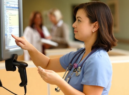 Medical Assistant touching medical record screen