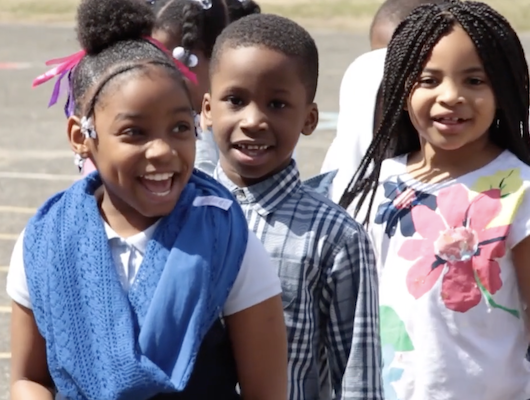 Video thumbnail showing kids smiling